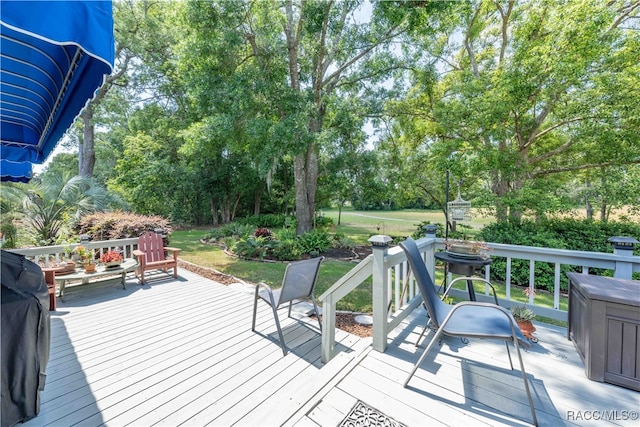 wooden deck featuring a lawn