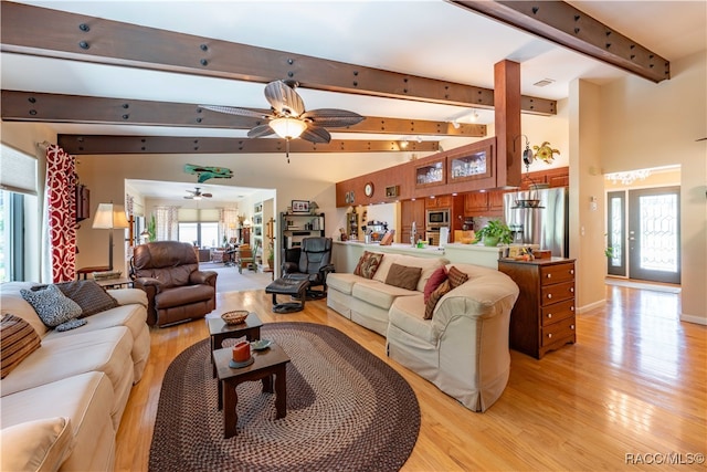 living room featuring lofted ceiling with beams, light hardwood / wood-style floors, and ceiling fan