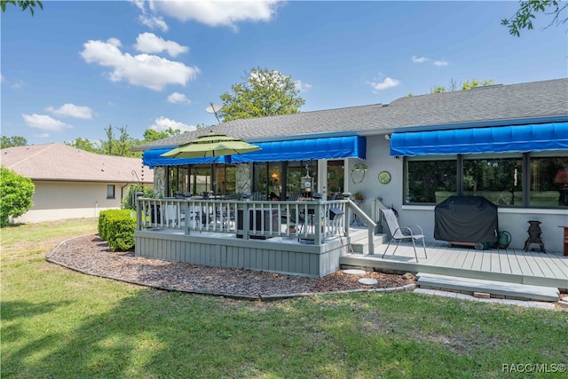 rear view of house with a deck and a lawn