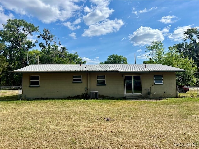 1029 NE 24th St, Ocala, FL 34470 - back of house with a lawn, fence, metal roof, and concrete block siding