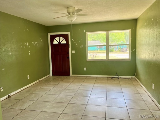 1029 NE 24th St, Ocala, FL 34470 - entryway with light tile patterned floors, baseboards, ceiling fan, and a textured ceiling
