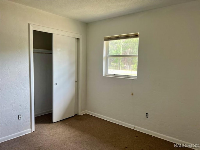1029 NE 24th St, Ocala, FL 34470 - unfurnished bedroom featuring baseboards, carpet, a closet, and a textured ceiling