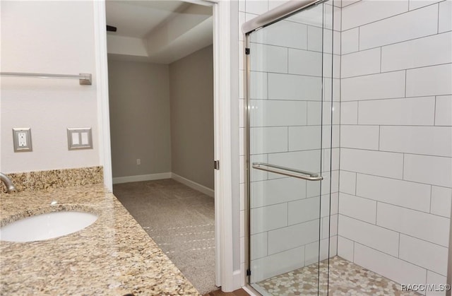 bathroom featuring a shower with door and vanity