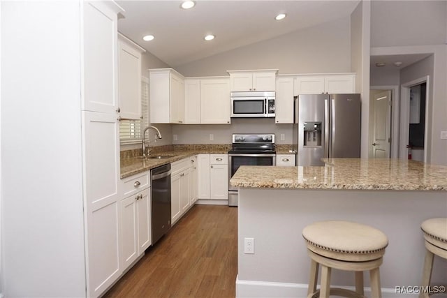 kitchen featuring white cabinetry, sink, vaulted ceiling, and appliances with stainless steel finishes