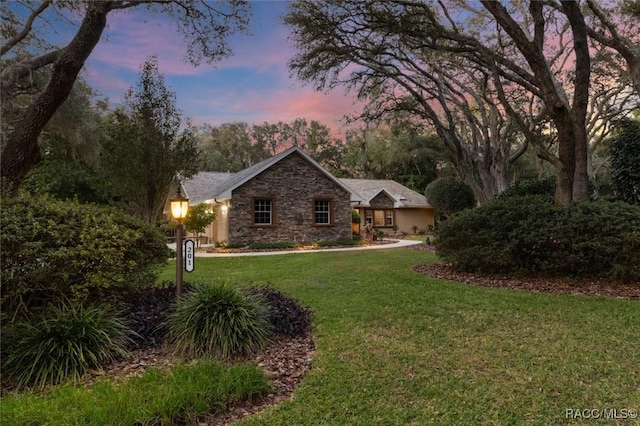 single story home featuring a front yard and stone siding