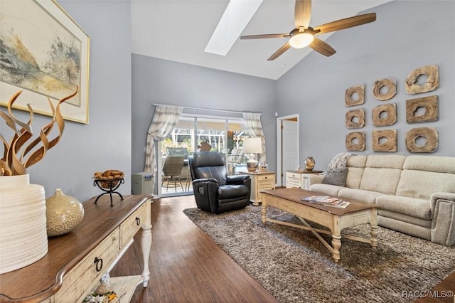 living area with ceiling fan, high vaulted ceiling, dark wood-style flooring, and a skylight