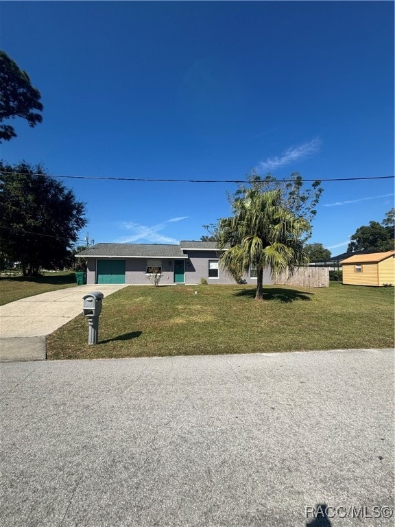 single story home featuring a garage and a front lawn