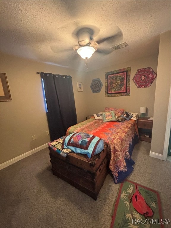 carpeted bedroom featuring a textured ceiling and ceiling fan