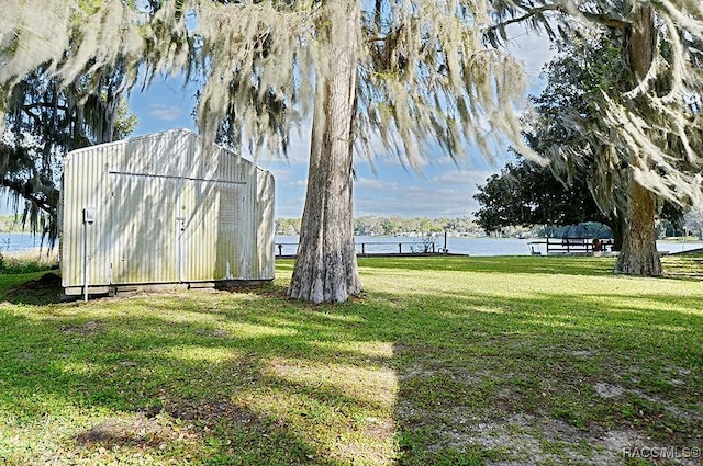 view of yard with a water view and a shed