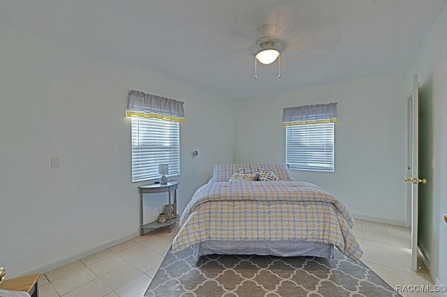 tiled bedroom featuring multiple windows and ceiling fan