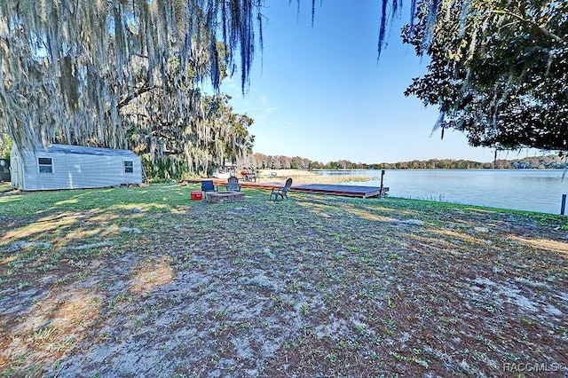 view of yard with a water view and a fire pit