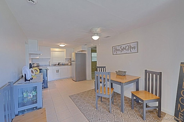 dining room with sink, light tile patterned floors, and ceiling fan