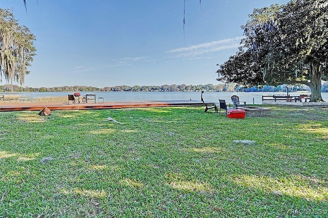 view of yard featuring a water view and an outdoor fire pit