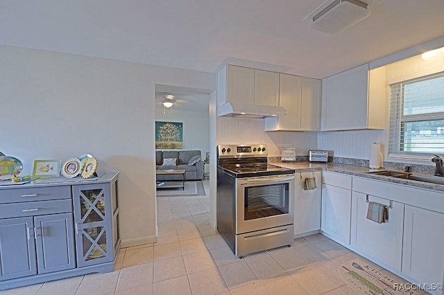 kitchen with white cabinetry, sink, light tile patterned floors, and stainless steel electric range