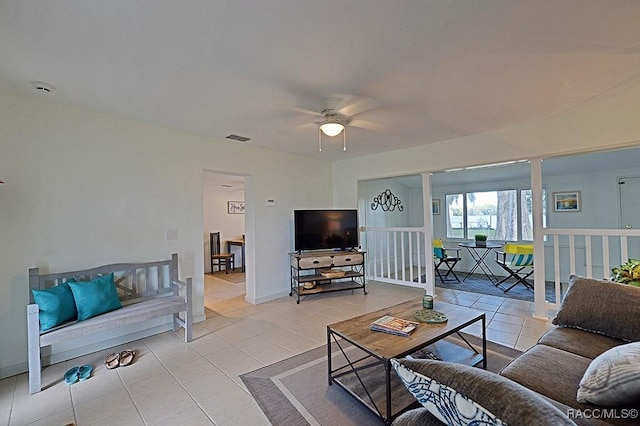 tiled living room featuring decorative columns and ceiling fan