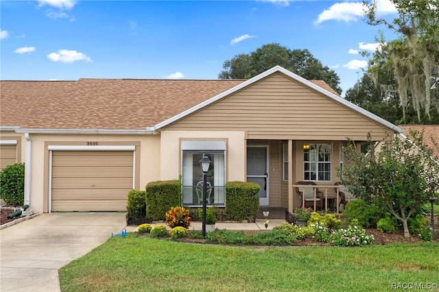 single story home with a porch, a garage, and a front lawn