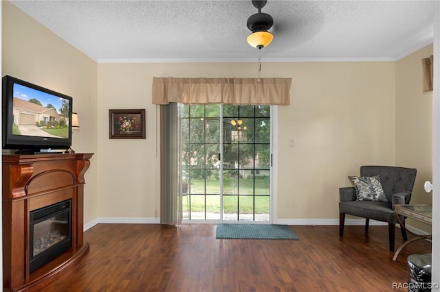 sitting room featuring a textured ceiling, dark hardwood / wood-style floors, ceiling fan, and ornamental molding