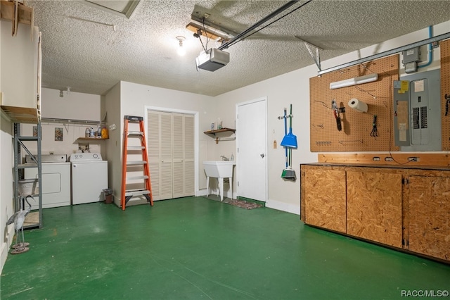 garage featuring washer and clothes dryer, electric panel, sink, and a garage door opener