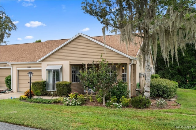 view of front of house with a garage and a front lawn