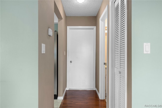 hall featuring dark hardwood / wood-style floors and a textured ceiling