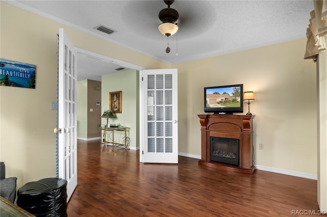 living room with ceiling fan, french doors, dark wood-type flooring, and a textured ceiling