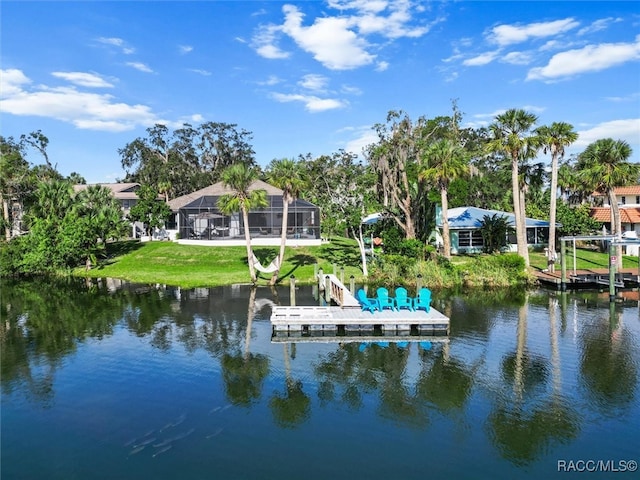 view of dock with glass enclosure, a water view, and a yard