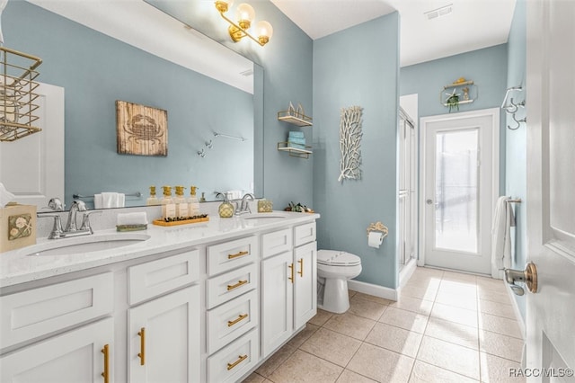 bathroom featuring toilet, vanity, tile patterned floors, and a shower with shower door