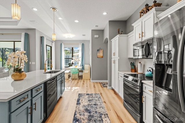 kitchen with pendant lighting, sink, wine cooler, white cabinetry, and stainless steel appliances