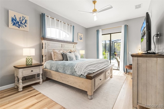 bedroom with multiple windows, light wood-type flooring, and access to exterior