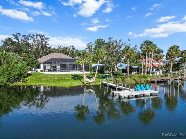 view of dock with a water view, a lanai, and a lawn