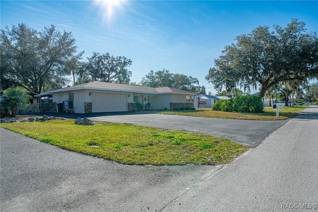 single story home featuring a front lawn and a garage