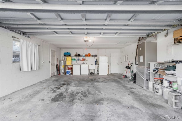 garage featuring washing machine and dryer, sink, water heater, a garage door opener, and white refrigerator