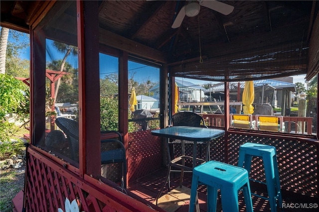 sunroom with ceiling fan and vaulted ceiling