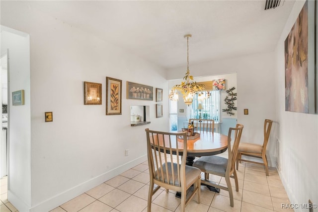 tiled dining room featuring a chandelier