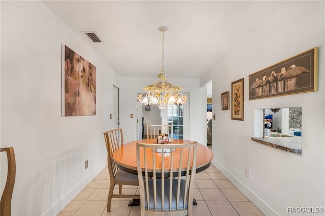 dining room with light tile patterned floors and a chandelier