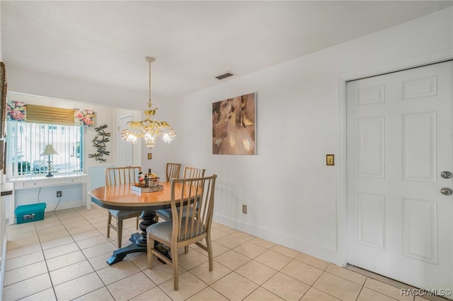 tiled dining room featuring a chandelier