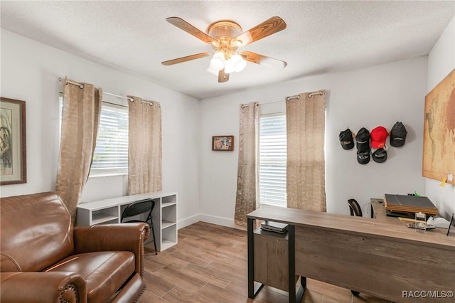 home office with ceiling fan, a healthy amount of sunlight, and a textured ceiling