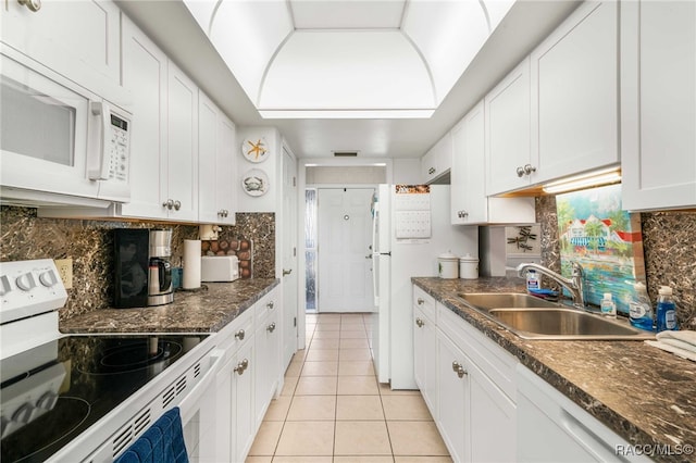 kitchen featuring sink, white cabinets, tasteful backsplash, and white appliances