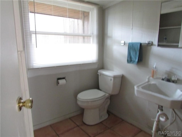 bathroom featuring toilet, a sink, and tile patterned floors