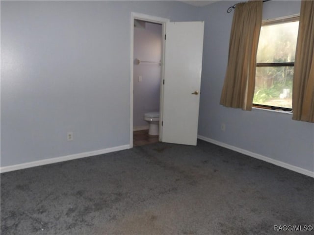 unfurnished bedroom with dark colored carpet