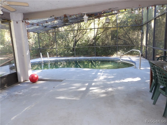 view of pool featuring glass enclosure and a patio