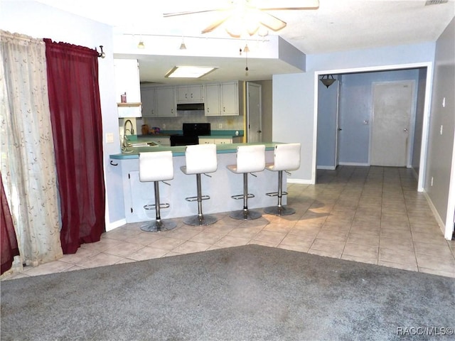 kitchen featuring sink, gray cabinetry, tasteful backsplash, light tile patterned floors, and ceiling fan