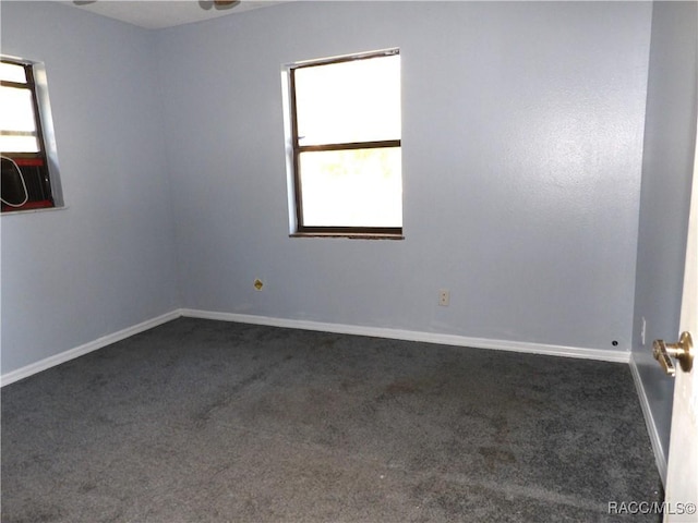 spare room with dark colored carpet