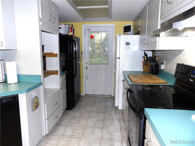 kitchen with light tile patterned flooring, backsplash, and black appliances