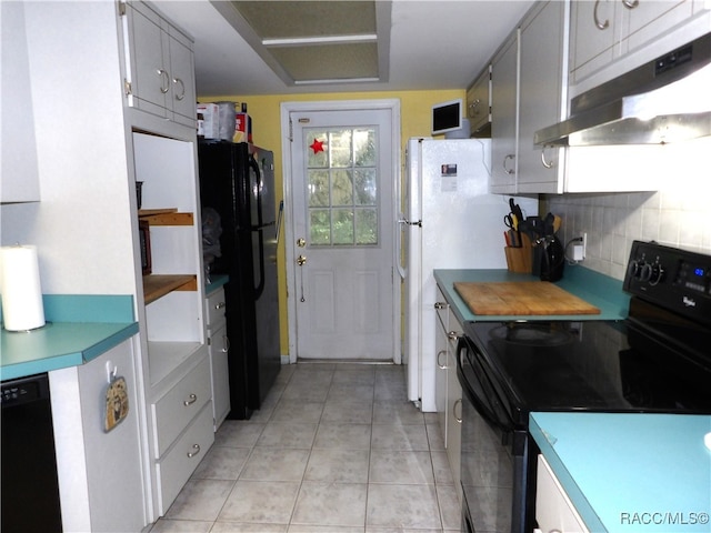 kitchen featuring light tile patterned flooring, tasteful backsplash, and black appliances