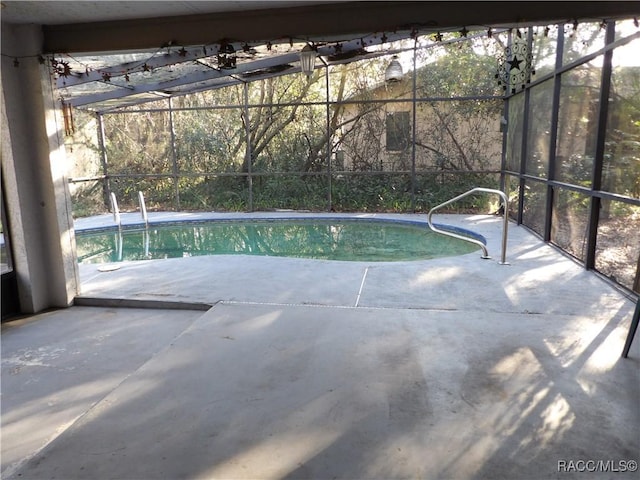 view of pool featuring glass enclosure and a patio