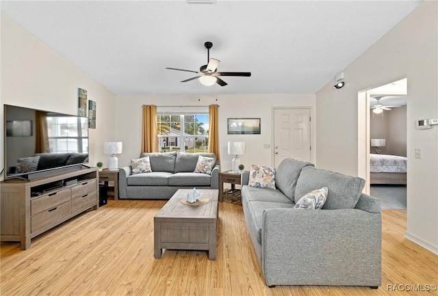 living room featuring ceiling fan, lofted ceiling, and light hardwood / wood-style floors