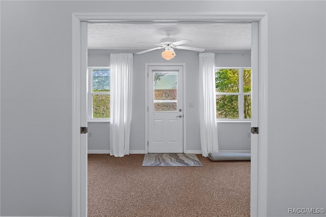 doorway to outside with carpet flooring and a textured ceiling