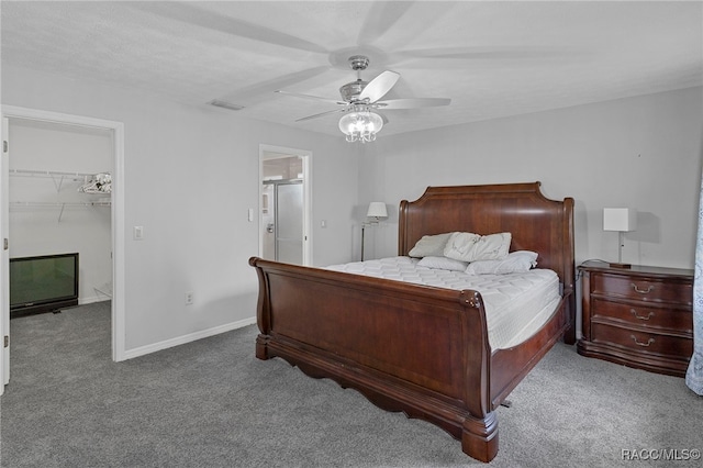 carpeted bedroom with ceiling fan, a walk in closet, and a closet