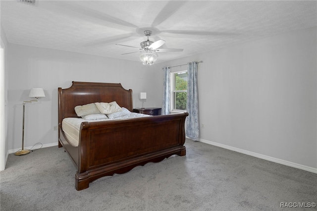 bedroom with a textured ceiling, ceiling fan, and light carpet